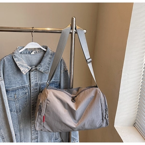 Detail of grey waterproof nylon fitness bag showing wide woven strap and durable texture