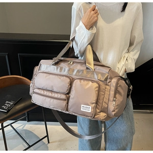 Dettaglio borsa da viaggio beige champagne con tasche multiple in nylon impermeabile