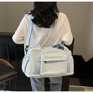 Detail showing back view of light blue canvas travel bag with multi-pocket design