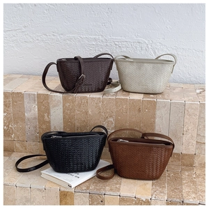 Detail of multi-color woven bucket bags with textured synthetic leather and silver zippers