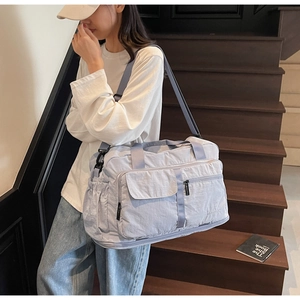 Close-up of lightweight light blue travel bag with multi-pocket design on stairs