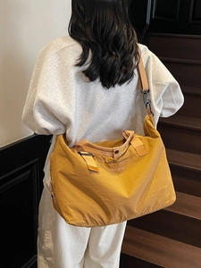 Large mustard yellow nylon travel bag with dual handles and detachable shoulder strap