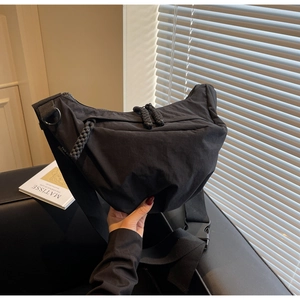 Detail of black crescent crossbody bag with durable zippers and adjustable strap