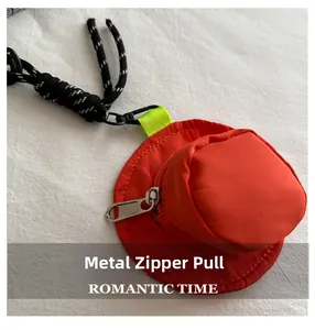 Detail of red hat-shaped mini coin purse featuring a silver metal zipper and woven lanyard