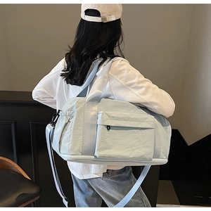 Detailed back view of a mint blue canvas travel bag showing large capacity and side pockets
