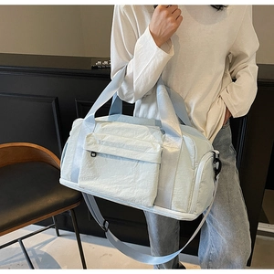 Detail of light blue waterproof nylon travel bag with front pocket and adjustable strap