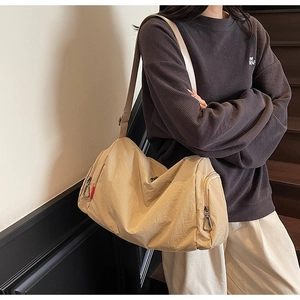 Detail view of large khaki canvas crossbody bag with adjustable strap and zip pocket