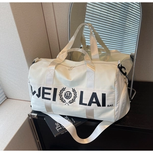 Detail of off-white travel bag with WEI LAI logo, shoulder strap, and durable handles