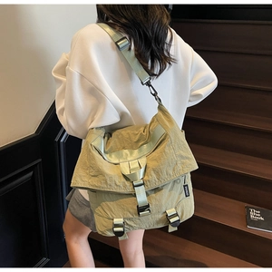 Detail van olijfgroene nylon roll-top rugzak met verstelbare gesp op houten trappen