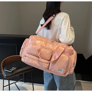 Dettaglio borsa da viaggio in nylon rosa impermeabile con tasche multiple e tracolla