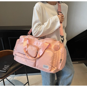 Borsa da viaggio rosa multitasche in materiale impermeabile indossata da una modella