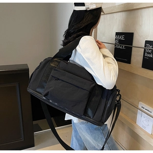 Detail of a large black canvas travel bag with durable straps for gym and yoga