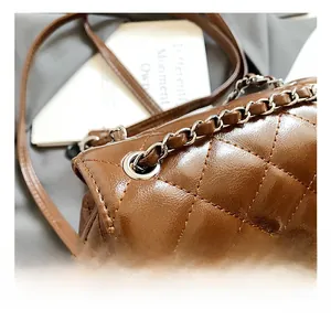 Detailed close-up of brown quilted leather texture and silver metallic twist-lock closure