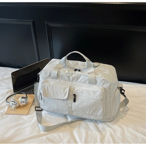 Close-up of the light gray travel bag showing reinforced handles and storage pockets