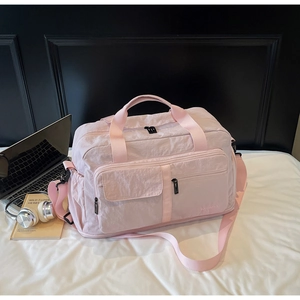 Detail of light pink waterproof travel bag with wet-dry separation and wide handles