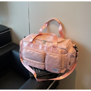 Dettaglio della borsa da viaggio rosa con tasche multiple e scomparti con cerniera