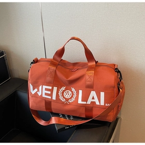 Terracotta sports bag with white WEI LAI logo on a black sofa next to books