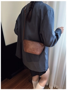 Detailed view of brown woven texture on cross-body bucket bag with adjustable strap