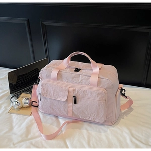 Light pink travel bag with separate wet-dry compartments on a modern bedroom background