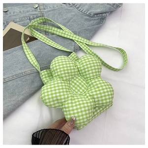 Gros plan d'un sac bandoulière en forme de fleur à carreaux verts et blancs sur denim