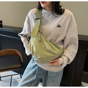 Olive green nylon crescent bag with woven zipper pull and adjustable strap detail