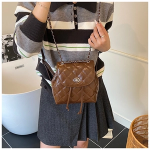 Detail showing brown quilted mini backpack with silver twist lock and chain strap