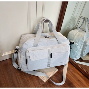 Light gray large capacity travel bag with dry-wet separation on wooden floor background