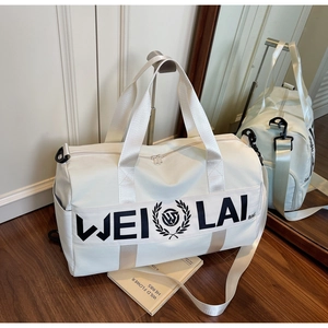 White large capacity sports gym bag with shoulder strap on wooden floor background