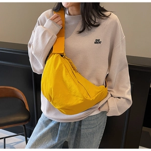 Detail of a bright yellow nylon crescent crossbody bag with adjustable wide shoulder strap