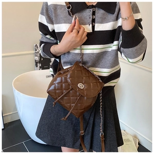 Detailed view of the brown quilted leather backpack with metal chain and turn-lock