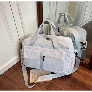 Close-up of lightweight travel bag with front pockets and adjustable shoulder strap