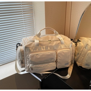 Dettaglio della borsa da viaggio grande con tasche multiple e etichetta sulla tela crema