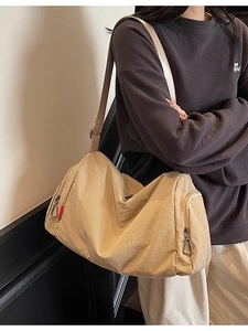 Large beige canvas crossbody bag with adjustable strap and side zipper pockets for women