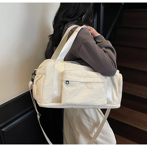 Detail view of large capacity canvas travel bag with pleated texture and adjustable strap
