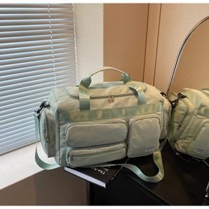 Vista dettagliata del borsone verde pallido con tasche multiple e tessuto in nylon resistente