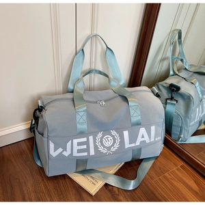 Detail of light blue gym bag with double handles and logo in a lifestyle mirror setting