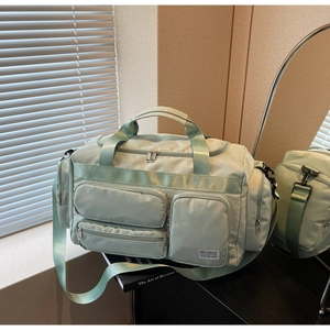 Dettaglio borsa da viaggio impermeabile verde menta con tasche multiple e tracolla
