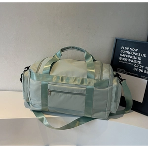 Dettaglio della borsa da viaggio verde menta con tasche multiple e doppi manici robusti