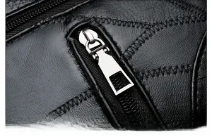 Macro shot of durable silver metal zipper on premium black textured leather handbag