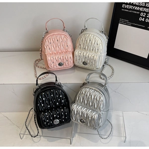 Detail view of mini quilted backpacks in pink, white, black and silver with rhinestones