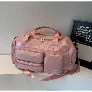 Dettaglio della borsa da viaggio rosa con tasche multiple a zip e manici rinforzati