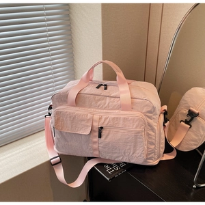 Close-up of pink nylon travel bag featuring waterproof fabric and adjustable straps