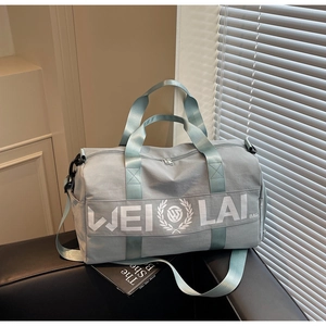 Detail of grey-blue fitness bag with adjustable strap and side zipper pocket on a sofa