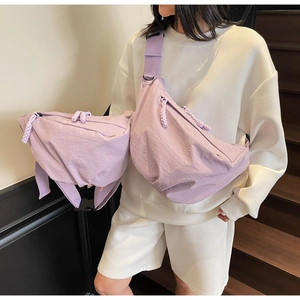 Detail view of light purple nylon dumpling bag with adjustable strap and braided zipper