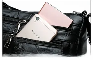Detail view of multi-pocket black PU leather crossbody bag with metal zippers