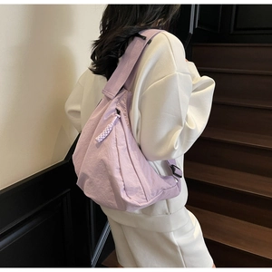 Close-up of light purple nylon crescent bag with woven zipper pull and adjustable strap