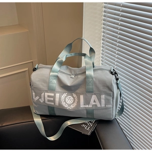 Detail of blue fitness travel bag with shoulder strap and side functional pocket