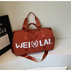 Brick red large fitness travel bag with top handles and adjustable shoulder strap on stand