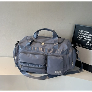 Dettaglio borsa da viaggio grigia in tessuto impermeabile con tasche multiple a cerniera