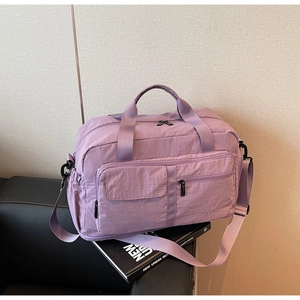 Close-up of lightweight lavender travel bag with waterproof fabric on a black sofa